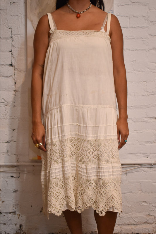 Delicate slip dress featuring intricate crochet details and soft cotton fabric. A timeless piece perfect for vintage fashion collectors and lovers of antique charm.