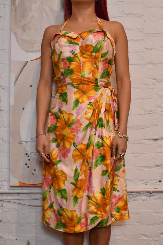 Classic mid-century design featuring vibrant floral prints and a flattering halter neckline. A timeless piece for vintage fashion lovers and sustainable wardrobe collectors.