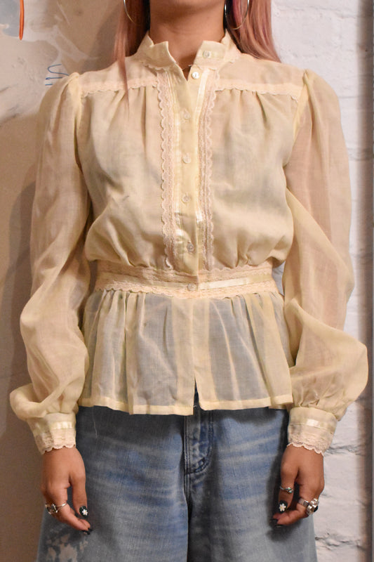 Soft cream-colored blouse featuring delicate lace and embroidery details, embodying the bohemian prairie style. A timeless piece for vintage fashion lovers and collectors.